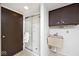 Functional bathroom includes a glass door shower, utilitarian sink and cabinet at 6454 Dean Rd, Indianapolis, IN 46220