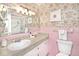 Charming bathroom features floral wallpaper, pink tile, and a mirrored vanity at 6454 Dean Rd, Indianapolis, IN 46220