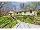 Charming home featuring stone retaining walls, lush lawn, and a winding gravel driveway at 6454 Dean Rd, Indianapolis, IN 46220