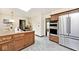 Well-lit kitchen with stainless steel appliances, an island cooktop, and oak cabinets at 6454 Dean Rd, Indianapolis, IN 46220