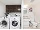 Combined laundry and bathroom space with modern machines and adjacent half bathroom setup at 6454 Dean Rd, Indianapolis, IN 46220