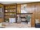 Living room featuring a stone fireplace, built-in bookshelves, and wood paneling at 6454 Dean Rd, Indianapolis, IN 46220