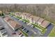 Aerial view of complex with parking, landscaping, pool, and wooded area at 6516 Emerald Hill Ct # 310, Indianapolis, IN 46237