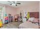 Charming bedroom with pink walls, hardwood floors, and playful decor at 6516 Emerald Hill Ct # 310, Indianapolis, IN 46237