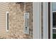 Close-up showcasing the building's exterior brick, intercom and numbered condo units at 6516 Emerald Hill Ct # 310, Indianapolis, IN 46237