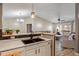 View of the sink and breakfast bar in a stylish kitchen open to a living area, with modern pendant lighting at 6516 Emerald Hill Ct # 310, Indianapolis, IN 46237
