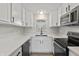 Well-lit kitchen featuring white cabinets, black hardware, stainless appliances, and laminate flooring at 652 E Tilden Dr, Brownsburg, IN 46112