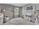 A well-lit Bedroom featuring an alphabet rug, neutral tones, and cozy seating area at 6622 Cardiff Cir, McCordsville, IN 46055
