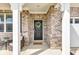 Inviting front porch featuring a black door with a green wreath and a seating area with a small table and chairs at 6622 Cardiff Cir, McCordsville, IN 46055