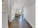 Long hallway featuring dark hardwood floors, white wainscoting, and views into other rooms of the house at 6622 Cardiff Cir, McCordsville, IN 46055