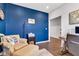 Comfortable home office featuring a blue accent wall, cozy chair, and view into hallway with wainscoting at 6622 Cardiff Cir, McCordsville, IN 46055