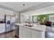 Open-concept kitchen flows into a bright living room with a gray sectional, and dark wood floors at 6622 Cardiff Cir, McCordsville, IN 46055