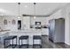 Modern kitchen with white cabinets, a large island with seating, stainless steel appliances, and dark wood floors at 6622 Cardiff Cir, McCordsville, IN 46055