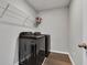 Modern laundry room with black appliances, storage shelf, and sleek flooring at 6622 Cardiff Cir, McCordsville, IN 46055