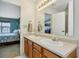 Bathroom with double sink vanity featuring wood cabinets and a view into another room at 7048 Tassel Meadow Dr, Indianapolis, IN 46217