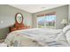 A bright bedroom with a large window is styled with a beautiful dresser and mirror at 7048 Tassel Meadow Dr, Indianapolis, IN 46217