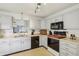 Spacious kitchen with white cabinets, black appliances, and a breakfast bar overlooking the living area at 7048 Tassel Meadow Dr, Indianapolis, IN 46217