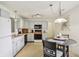 Bright kitchen features white cabinets and modern appliances with an adjacent dining area at 7048 Tassel Meadow Dr, Indianapolis, IN 46217