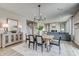Open concept dining area with modern chandelier, wood table, and view into the spacious living room at 7331 Deerberg Dr, Indianapolis, IN 46259