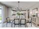 Elegant dining room with a chandelier and wood table with views to the modern kitchen at 7331 Deerberg Dr, Indianapolis, IN 46259