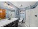 Updated bathroom with modern vanity, light fixtures, and glass enclosed shower at 7424 Campfire Run, Indianapolis, IN 46236