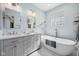 Bright bathroom features a soaking tub, double vanity, and marble floors for a luxurious feel at 7424 Campfire Run, Indianapolis, IN 46236