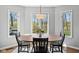 Bright dining area featuring a wood table set, modern lighting, and large windows with scenic outdoor views at 7424 Campfire Run, Indianapolis, IN 46236