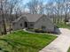 Charming brick home with a well-manicured lawn, lush landscaping, and a concrete driveway at 7424 Campfire Run, Indianapolis, IN 46236