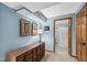 Hallway leading to updated bathroom with modern vanity, light fixtures, and tiling at 7424 Campfire Run, Indianapolis, IN 46236