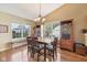 Cozy dining area with a chandelier, hardwood floors, large windows, and a view into the backyard at 7450 Deville Ct, Indianapolis, IN 46256