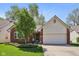 Charming brick home featuring a two-car garage, landscaped front yard, and a well-maintained lawn at 7450 Deville Ct, Indianapolis, IN 46256