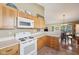 Functional kitchen with oak cabinets, laminate countertops, and an adjacent dining area with plenty of natural light at 7450 Deville Ct, Indianapolis, IN 46256