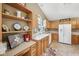 Well-maintained kitchen featuring oak cabinets, white appliances, and a breakfast bar with ample counter space at 7450 Deville Ct, Indianapolis, IN 46256