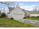 View of the home's side, showing the two-car attached garage, lush lawn, and well-kept landscaping at 7640 Bay Shore Dr, Indianapolis, IN 46240