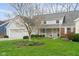 View of the home's front, highlighting the attached two-car garage and quaint, covered porch at 7640 Bay Shore Dr, Indianapolis, IN 46240