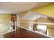 Open hallway with hardwood floors and glass railing looking over an attractive Gathering room at 7640 Bay Shore Dr, Indianapolis, IN 46240