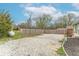 The backyard is gravel-filled for parking and is enclosed by a tall wooden privacy fence at 7748 S State Road 39, Clayton, IN 46118