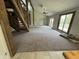 Spacious living room with vaulted ceilings, modern ceiling fan, large windows, and rustic wooden staircase at 7748 S State Road 39, Clayton, IN 46118