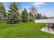 Manicured backyard featuring a green lawn, trees and an outdoor seating area at 7782 Rose Ln, Ingalls, IN 46048