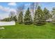 Well-kept backyard featuring a green lawn, trees, fencing and an outdoor seating area at 7782 Rose Ln, Ingalls, IN 46048