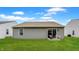Cozy backyard patio area with green grass and a sliding glass door to access the home's interior at 7782 Rose Ln, Ingalls, IN 46048