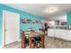 Dining area with a table, wood floors and decorated blue walls adjoining the kitchen at 7782 Rose Ln, Ingalls, IN 46048