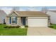 Charming single-story home featuring a brick facade, attached two-car garage, and a well-manicured front lawn at 7782 Rose Ln, Ingalls, IN 46048