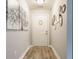 Inviting hallway with light gray walls, wood-look flooring, and decorative wall art creating a warm entrance at 7782 Rose Ln, Ingalls, IN 46048