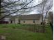 View of the backyard showcasing a large lawn, established garden beds, and a fenced perimeter at 8106 Captain Dr, Avon, IN 46123