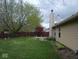 Spacious backyard featuring a lush lawn, mature trees, and a concrete patio at 8106 Captain Dr, Avon, IN 46123