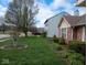 Charming front yard with mature landscaping, green lawn, and a brick and vinyl facade home at 8106 Captain Dr, Avon, IN 46123