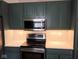 Well-equipped kitchen with stainless steel appliances, modern lighting, and green cabinets at 8106 Captain Dr, Avon, IN 46123