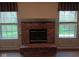 Cozy living room featuring a classic brick fireplace and bright windows with charming valances at 8106 Captain Dr, Avon, IN 46123