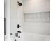 Bright, white bathroom featuring a shower and bathtub with black fixtures and a glass enclosure at 8155 Hunt Club Rd, Zionsville, IN 46077